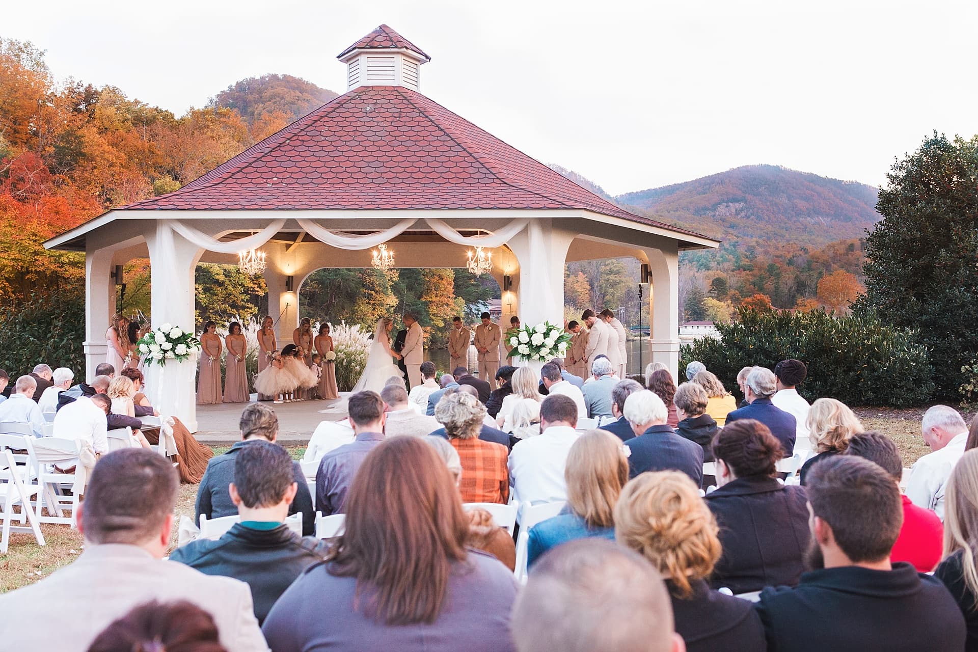 Outdoor wedding ceremony with lake and fall leaves in background by kathy beaver photography, Asheville NC