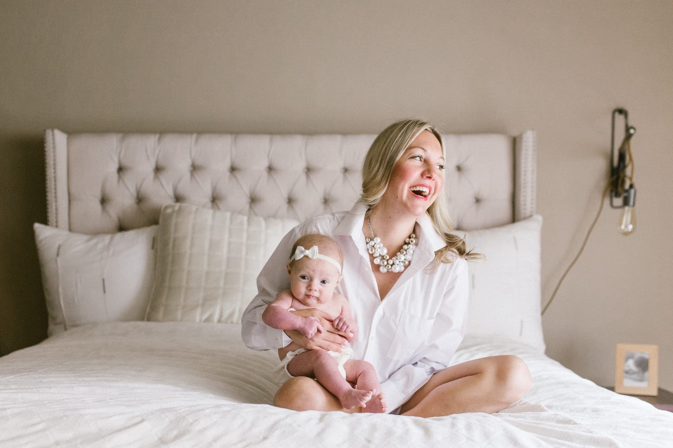 Mom on white bed with 3 month old.