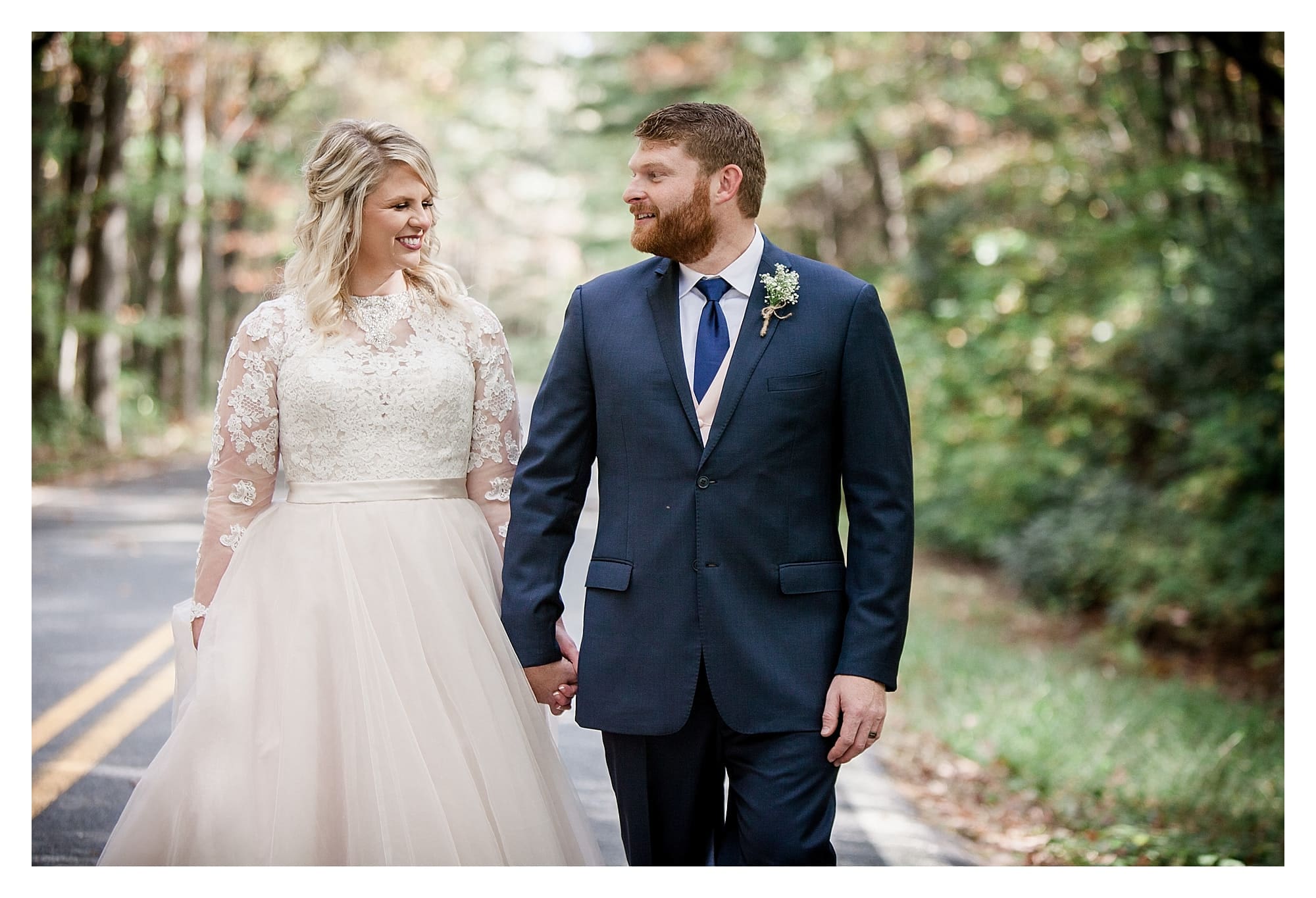 Bride and groom in road with fall foliage