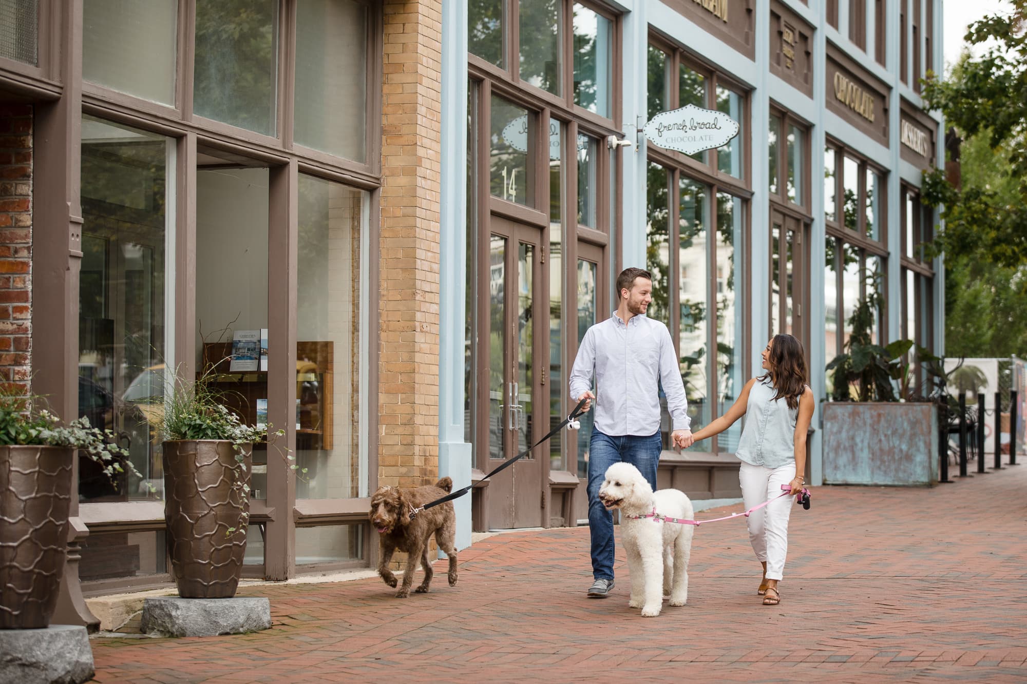 Couple walking their two poodles in Downtown Asheville North Carolina photography done by Kathy Beaver.