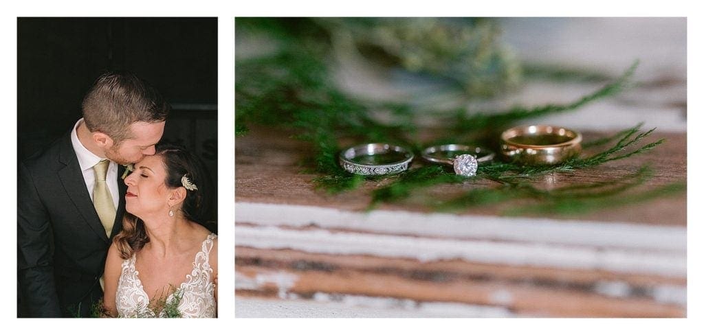 Groom kissing brides forehead and close up of weddings rings laying on greenery on top of table - kathy beaver photography