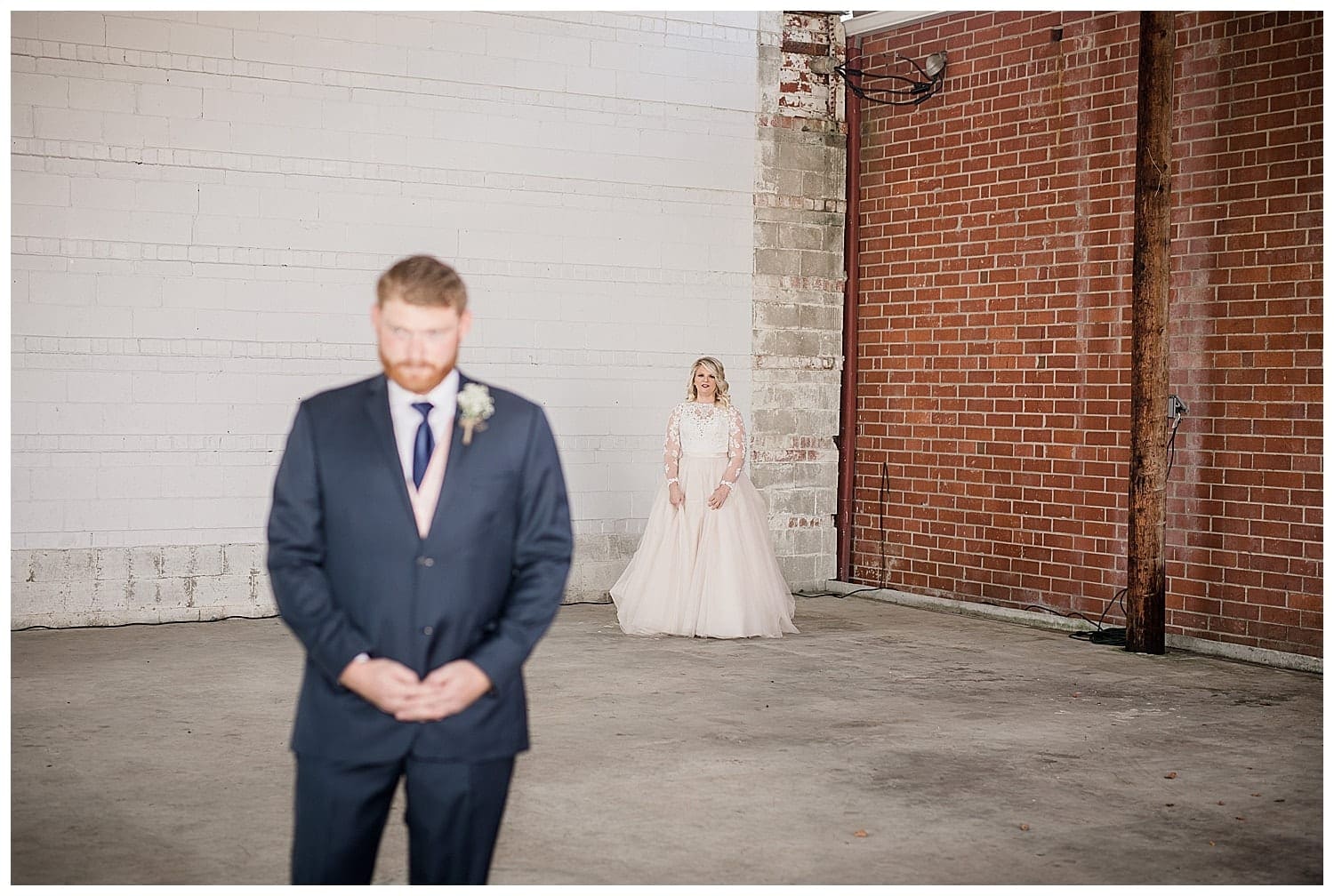Photo of bride standing a few feet behind groom awaiting their first look of one another on their wedding day