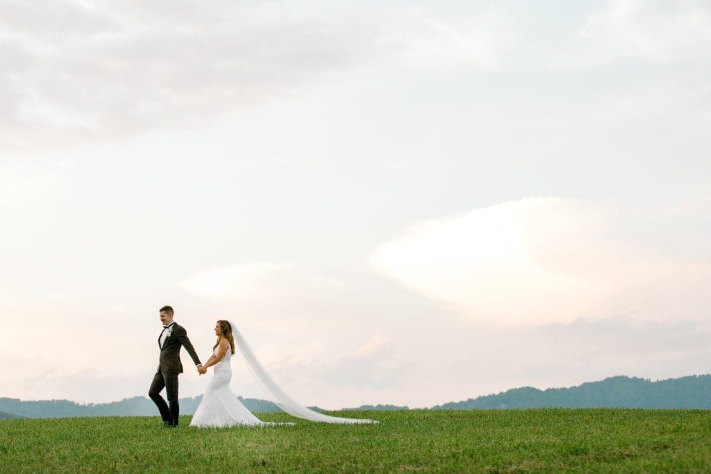The bride and groom walk holding hands | Kathy Beaver Photography | Asheville Wedding Photographer