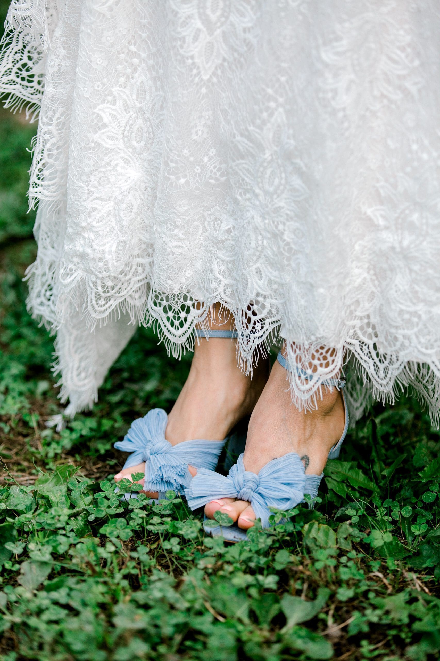 A close up detail photo of the bride's lace gown with blue bows on her shoes | Kathy Beaver Photography | Asheville Wedding Photographer