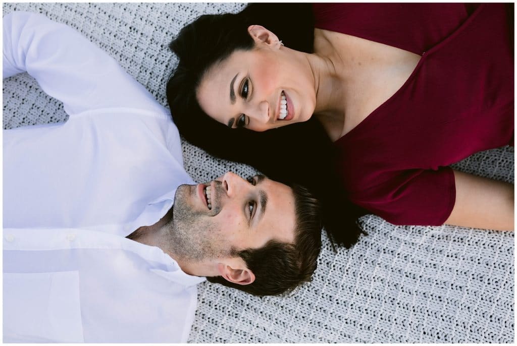 Nicole and Steve lay on a blanket together in the mountains | Asheville Engagement Photographer