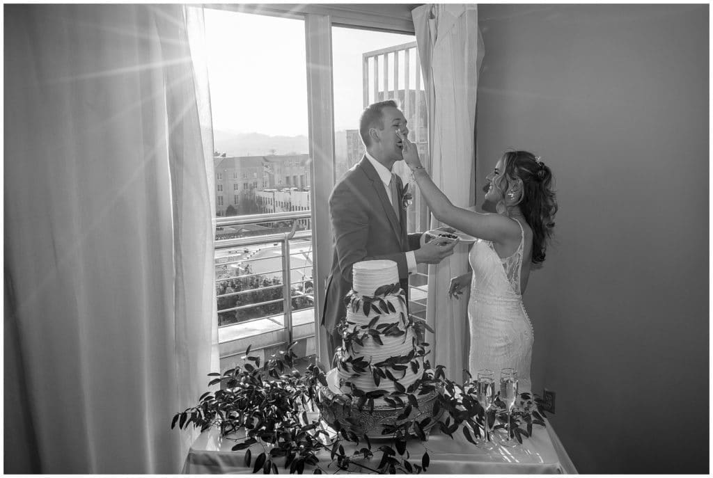 black and white photo of bride and groom cutting the cake