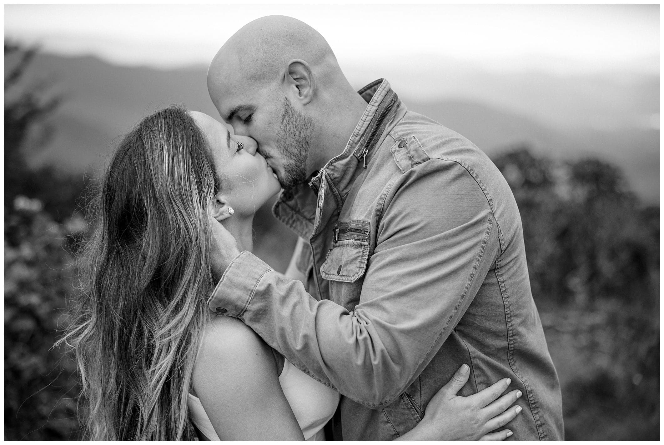 Couple shares a kiss on the mountain for their engagement session