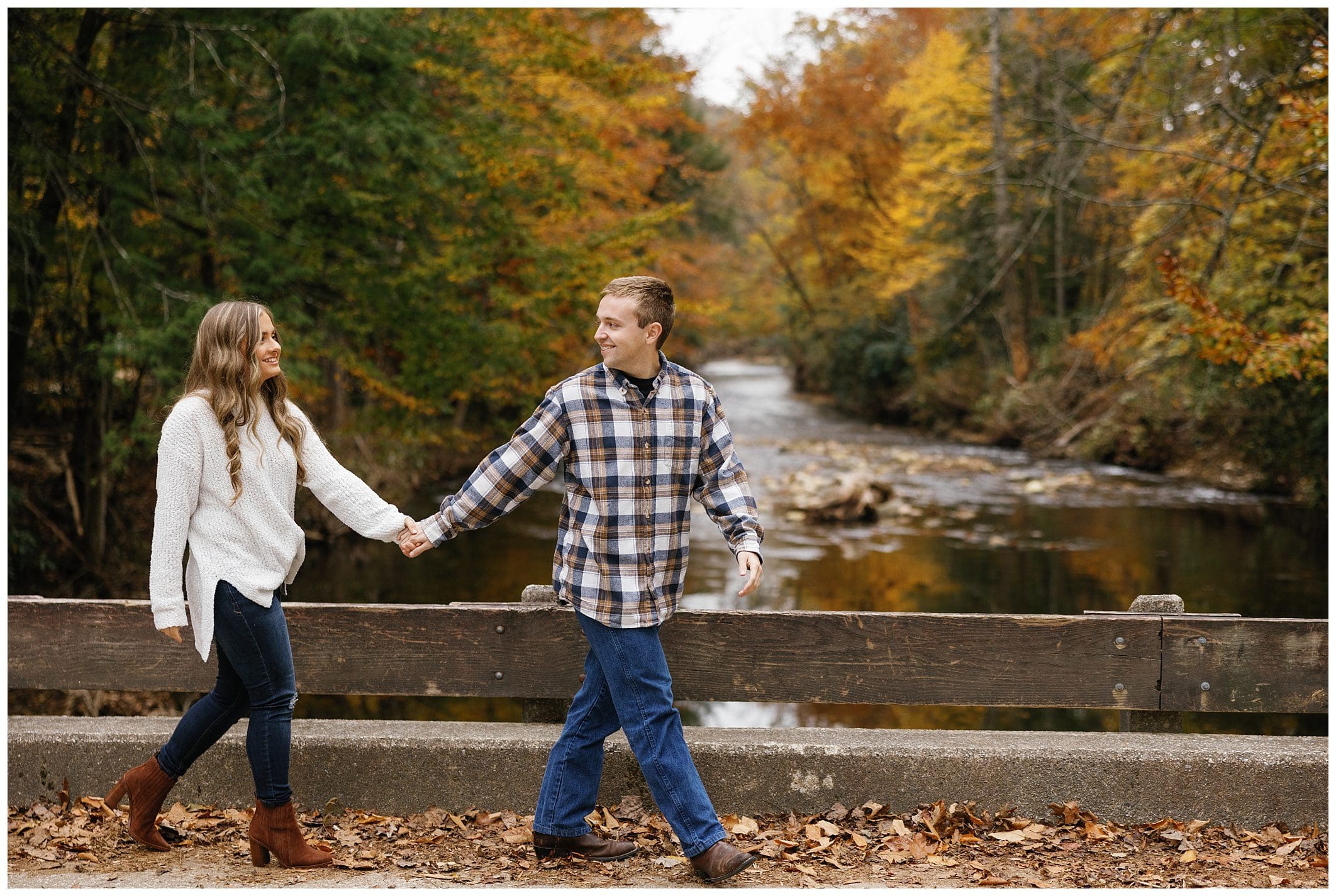 Couple walking in front of river and fall leaves during their mountain engagement