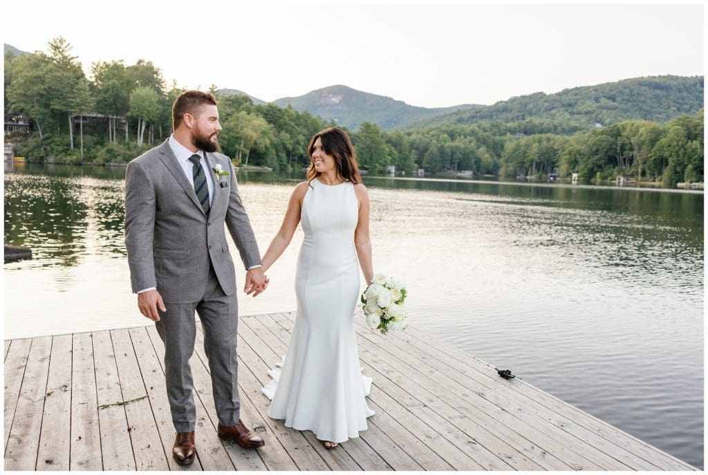Bride and groom pose for portraits in front of Lake Toxaway