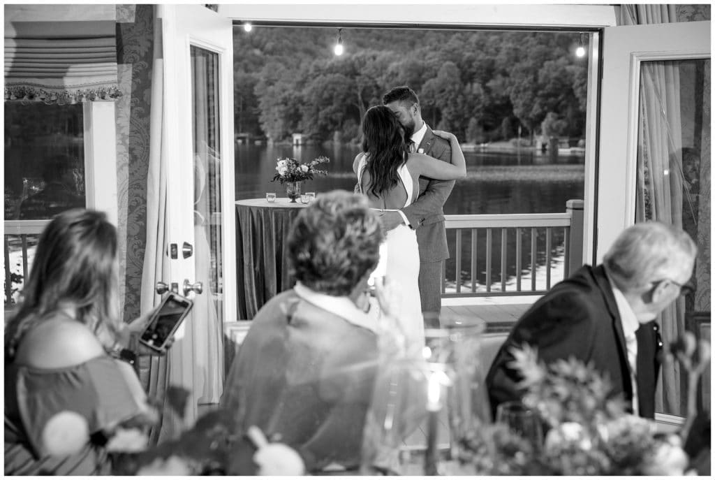Couple shares first dance at intimate wedding in front of a lake