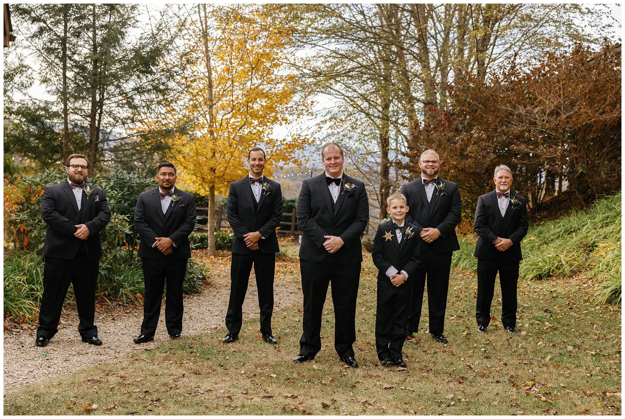 groom and groomsmen posing outdoors in the fall
