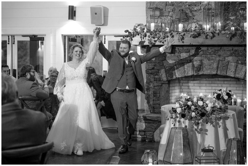 black and white photo of bride and groom entering their reception at their wedding at Chestnut Ridge