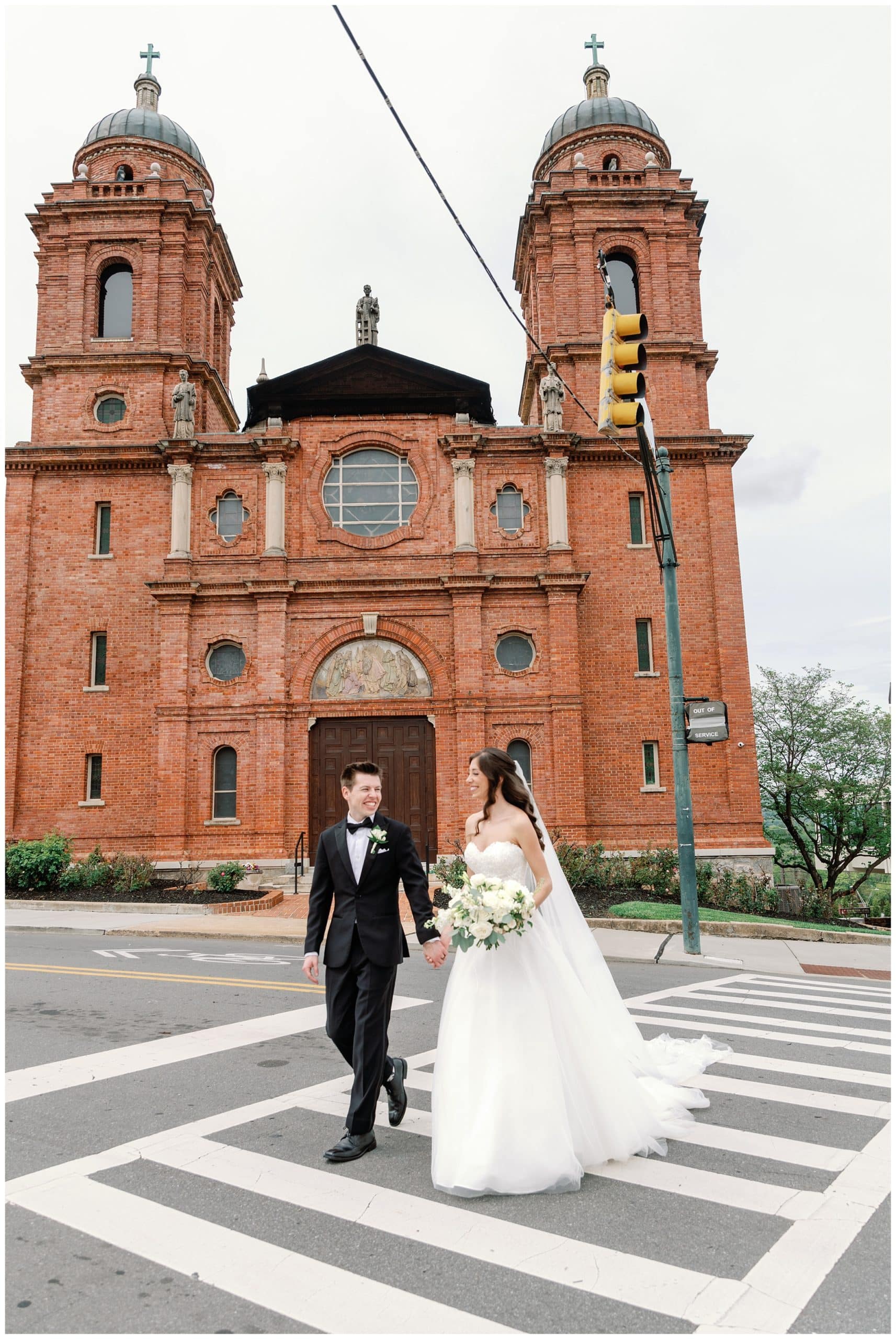 bride and groom walk outside of  basilica of st lawrence 