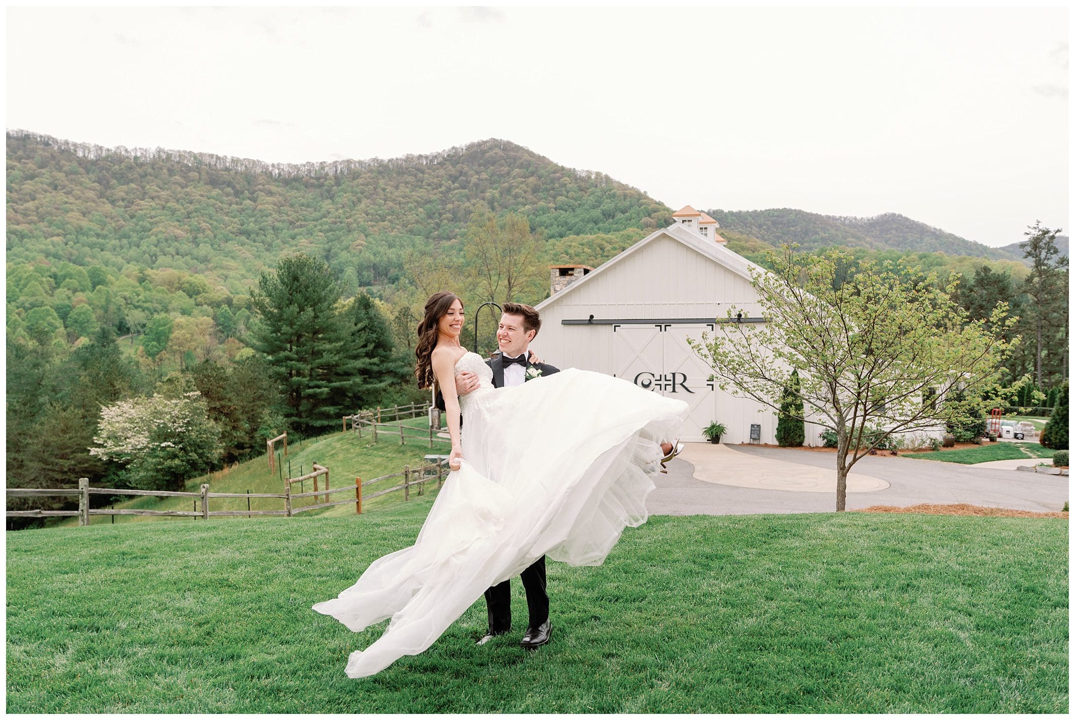groom picks up and swings bride around at Chestnut Ridge white farmhous venue 