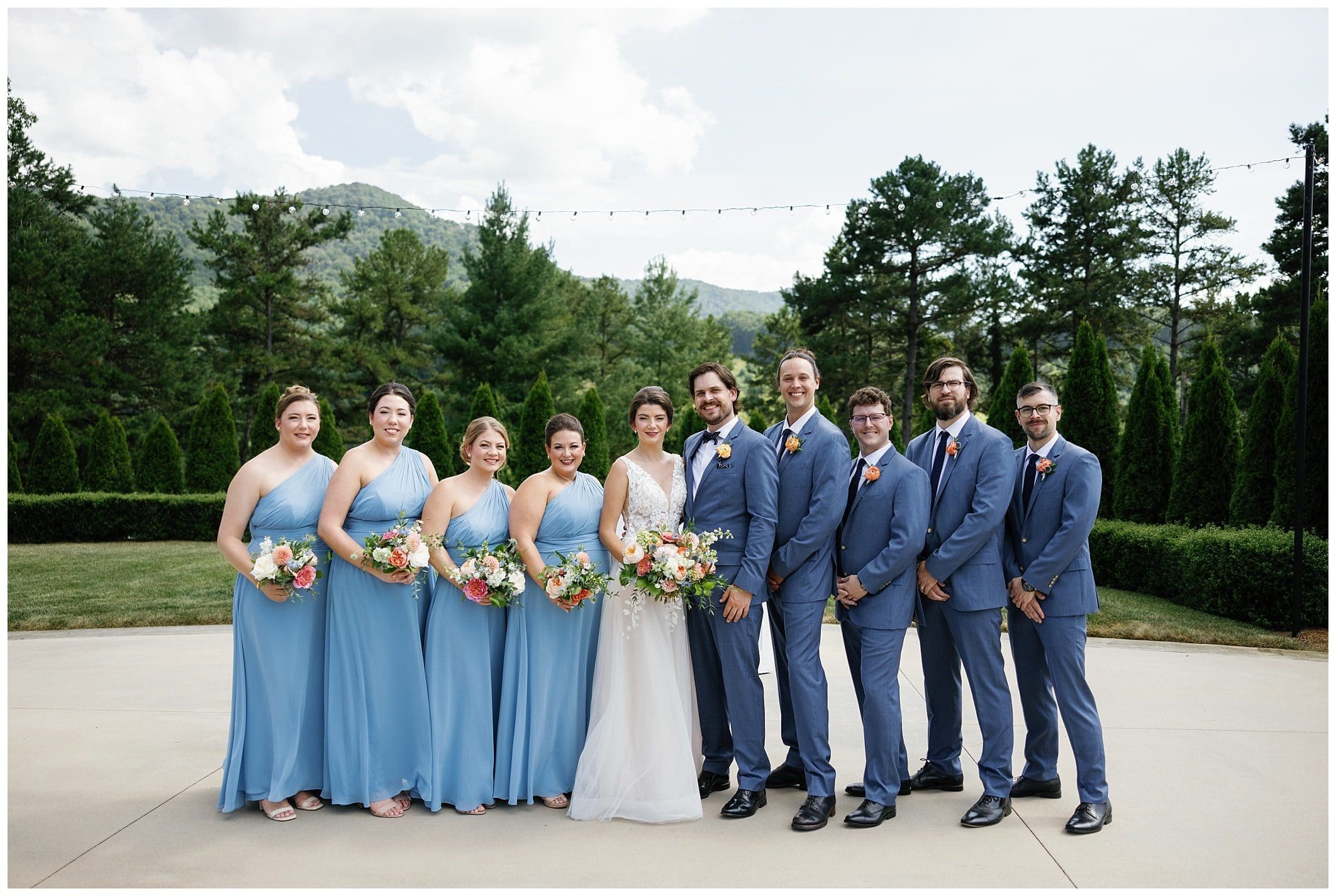 A group of bridesmaids and groomsmen pose for a photo.