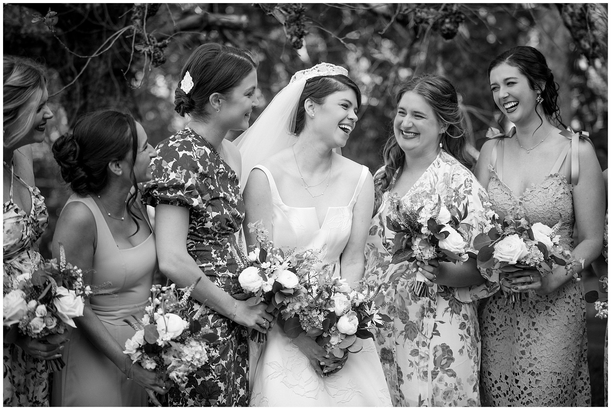 A black and white photo of bridesmaids laughing.
