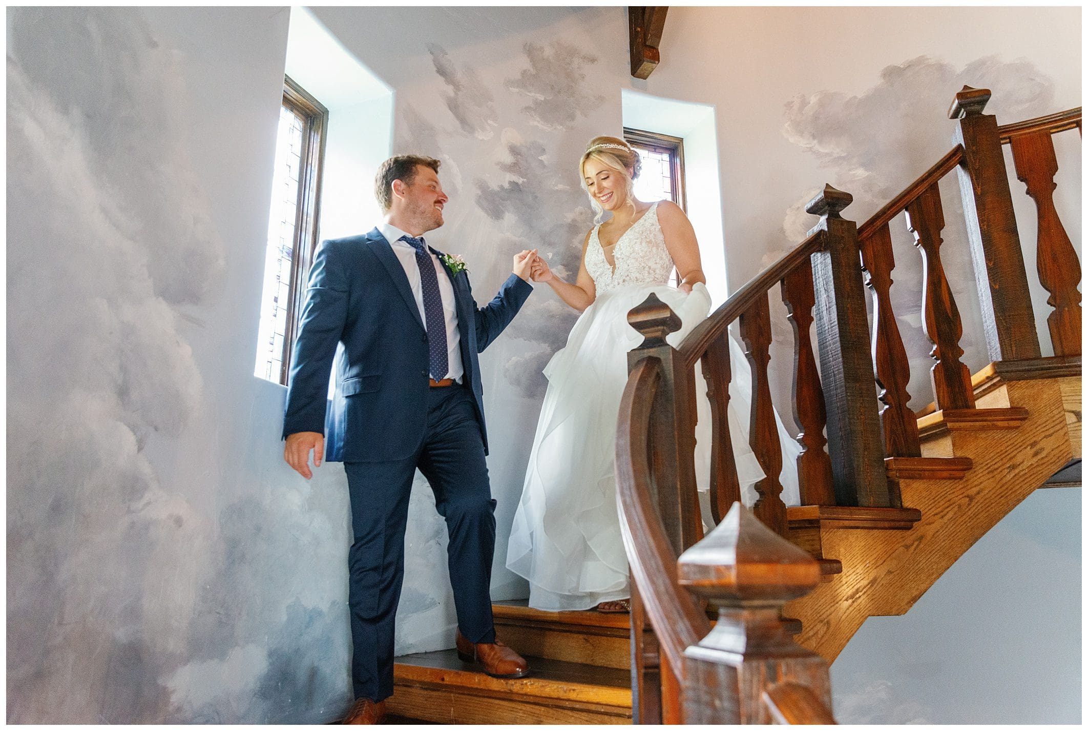 A bride and groom standing on a staircase.