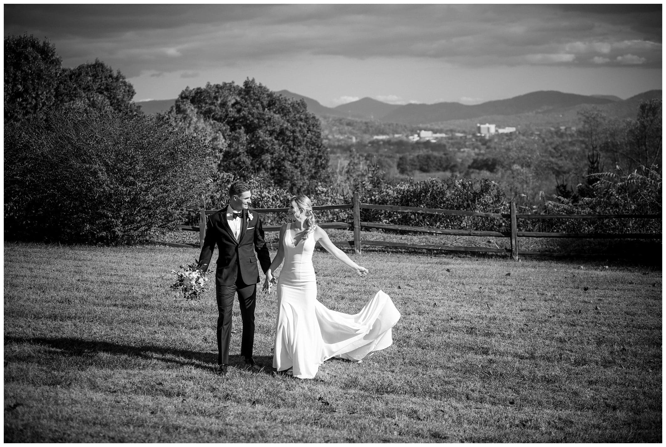 A bride and groom having a fall wedding at Crest Center, standing in a field with mountains in the background.