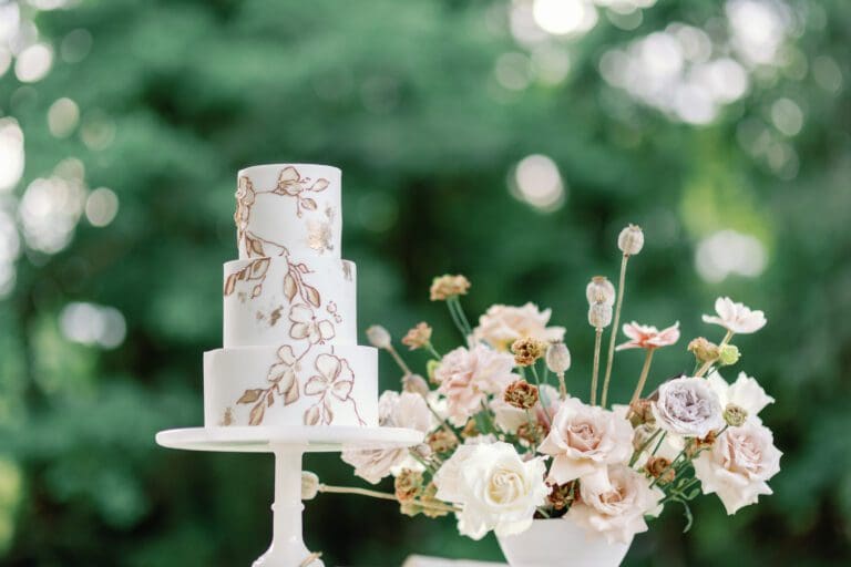 A stunning white wedding cake on a table adorned with beautiful flowers, providing the perfect wedding inspiration at Casa Carolina.