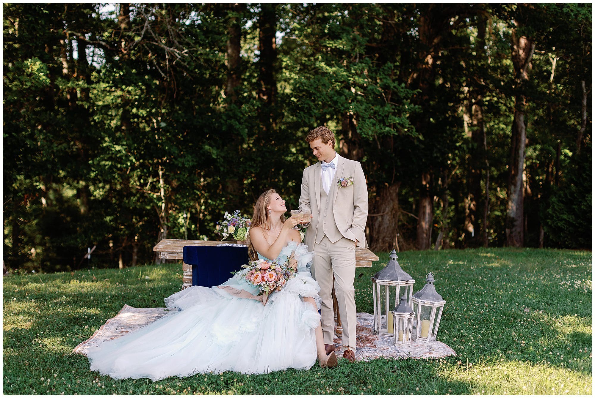 A Parisian-inspired summer wedding with the bride and groom sitting on a blanket in the grass at The Ridge.