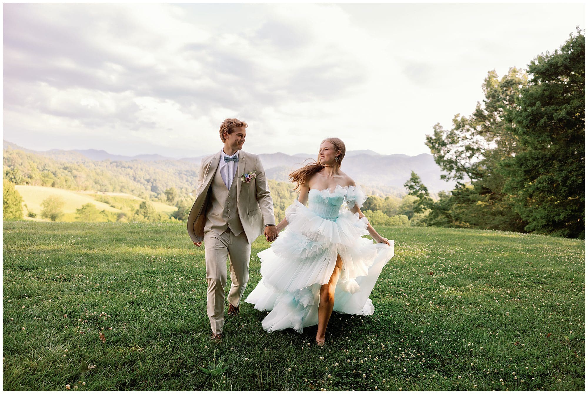 A Parisian-inspired summer wedding at The Ridge, with the bride and groom walking through a grassy field.