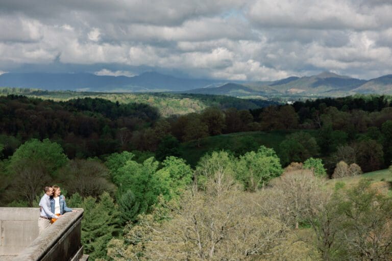 couple overlooks mountains on terrace during their spring engagment photo session